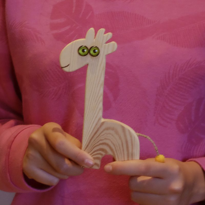 Jirafa de madera, con niña de 12 años