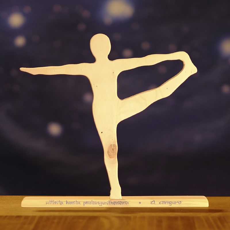 Postura de yoga "el canguro" en madera, sobre base de madera con nombre en sánscrito y en castellano.