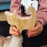 Gato de madera en manos de una niña de 4 años