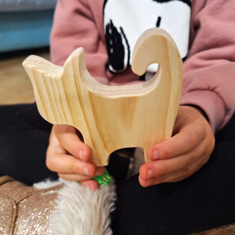 Gato de madera en manos de una niña de 4 años