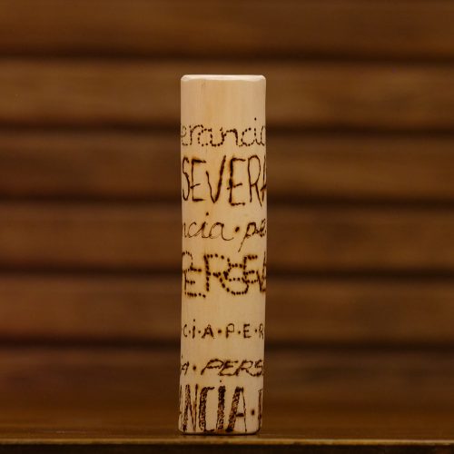 Tótem "perseverancia", con esta palabra pirografiada 7 veces.