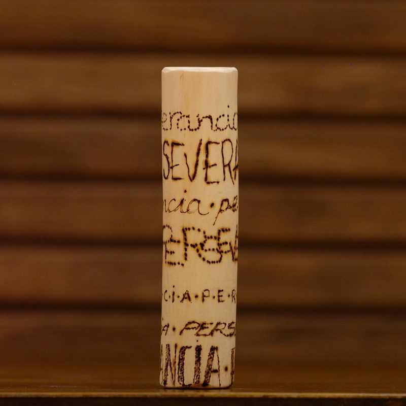 Tótem "perseverancia", con esta palabra pirografiada 7 veces.