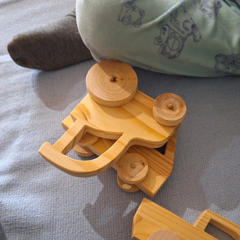 Niño jugando con tractor de madera