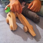 Coche de madera, bólido de carreras, con niña