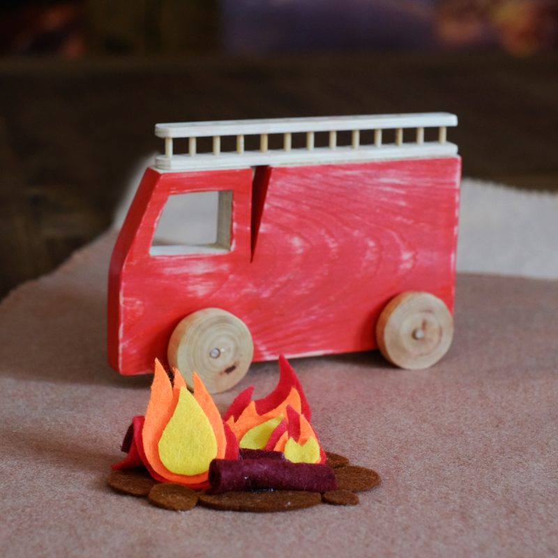Coche bomberos de madera, pintado de rojo, con su escalerilla y fuego