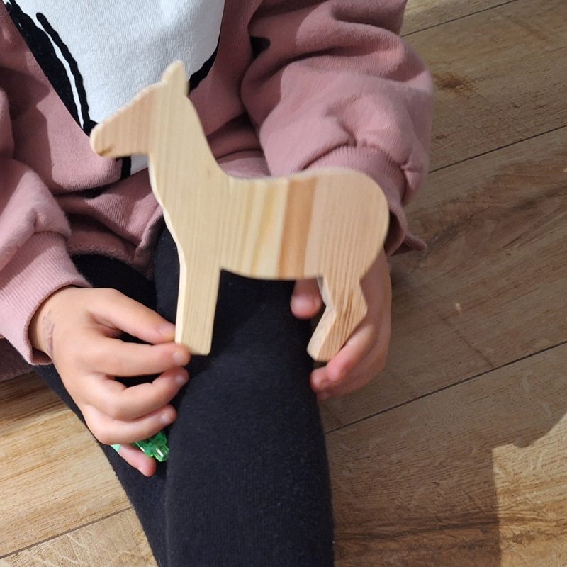 Burrito de madera en manos de una niña de 4 años