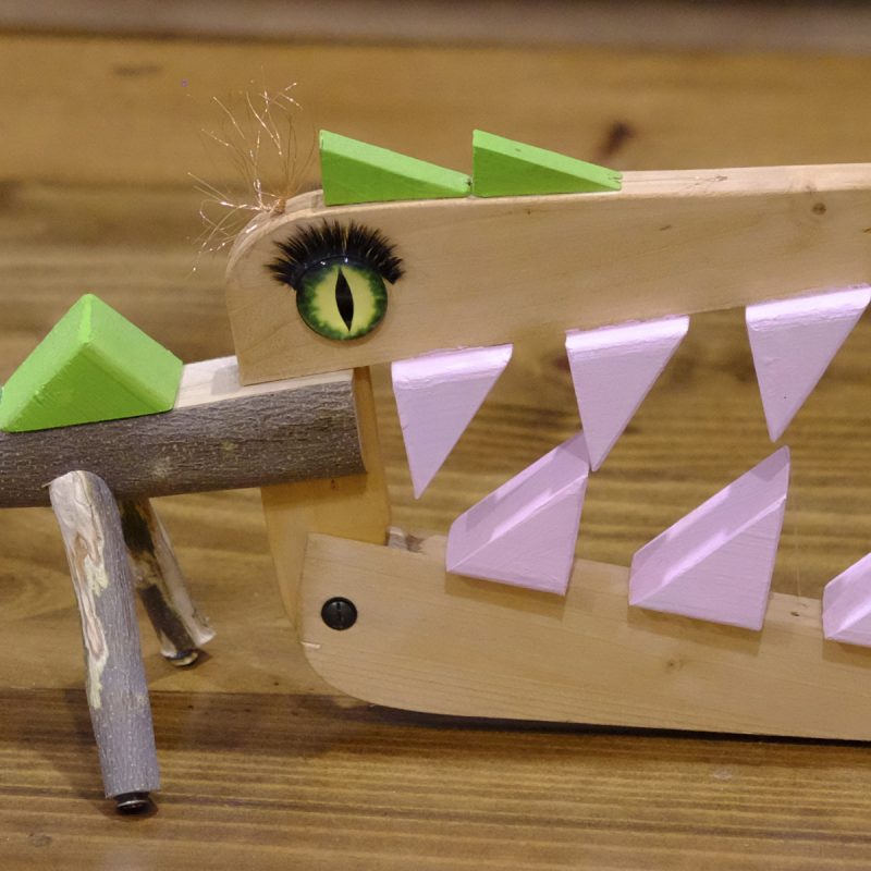 Detalle de cocodrilo de madera, juguete con un gran ojo y pestañas