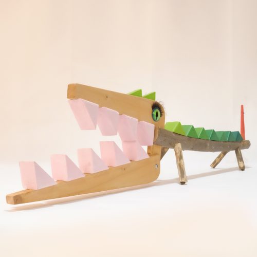 Cocodrilo de madera, con grandes dientes de color rosa