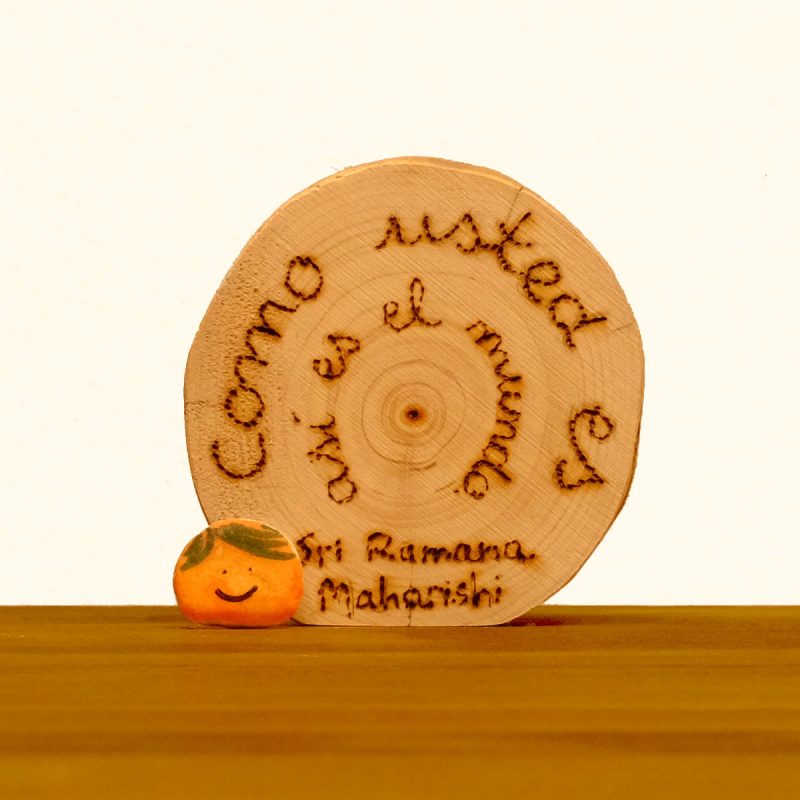 Rueda de madera con texto pirografiado de Ramana Maharishi.