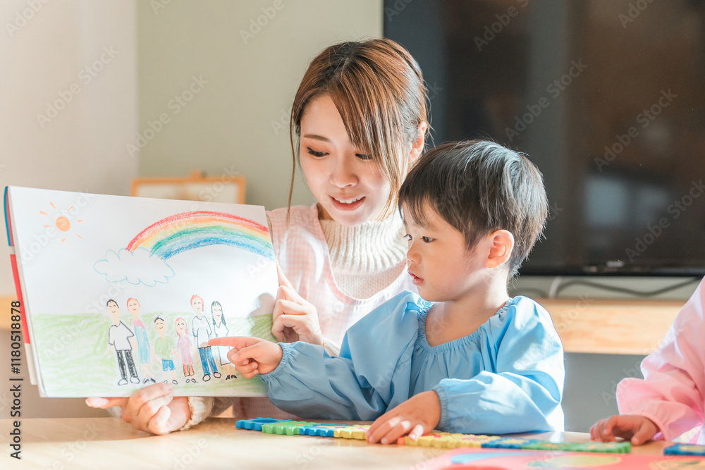 Profesora con un niño y la lámina de kamishibai que él ha dibujado