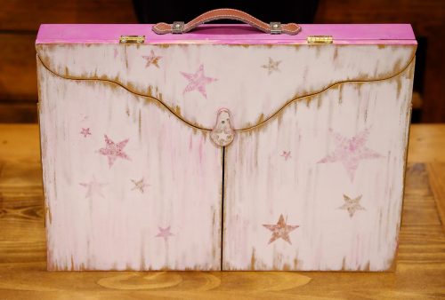 El kamishibai es como un maletín cuando está cerrado: modelo frambuesa, decorado con estrellas.